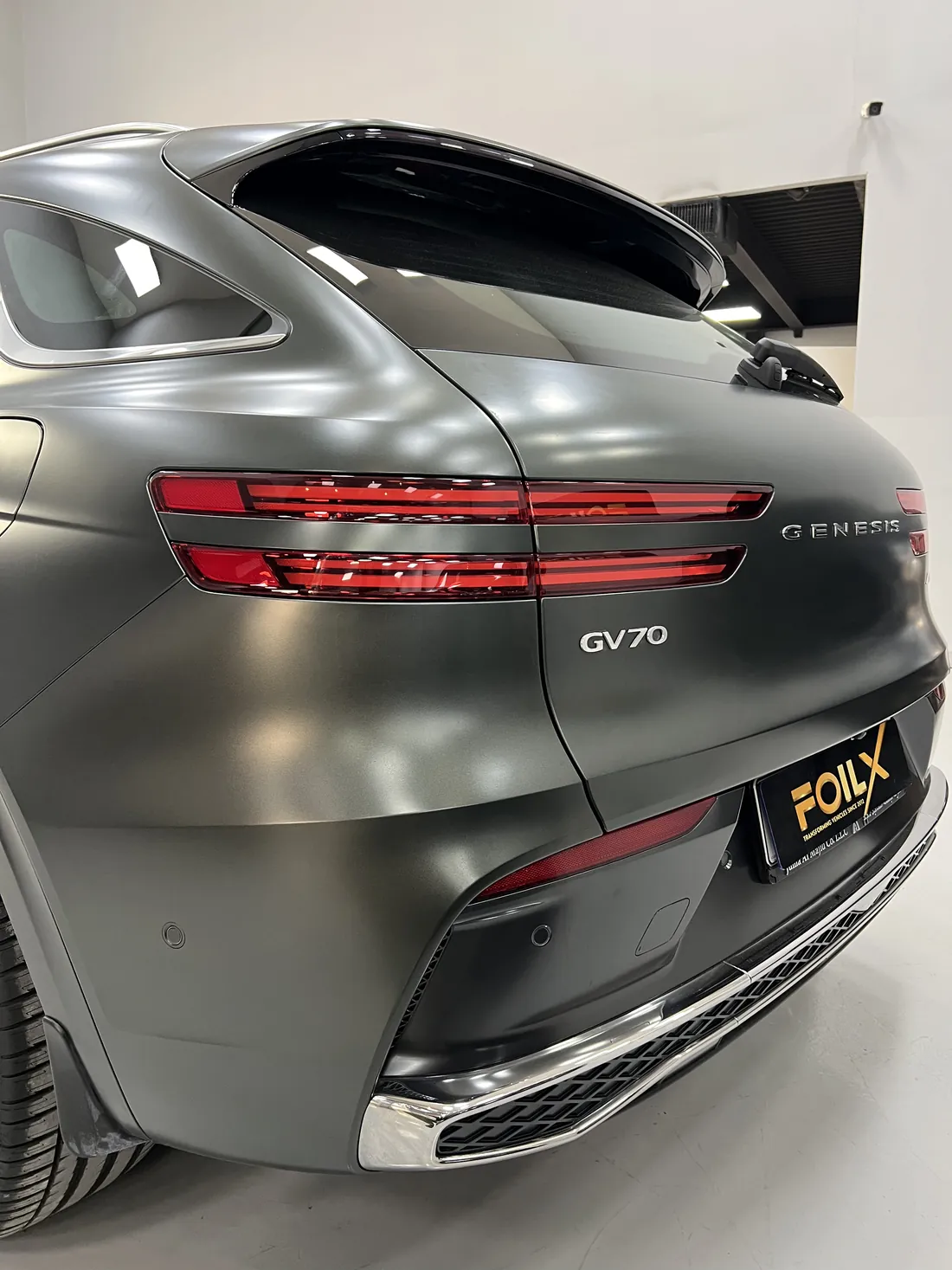 Rear view of a Genesis GV70 in matte black wrap